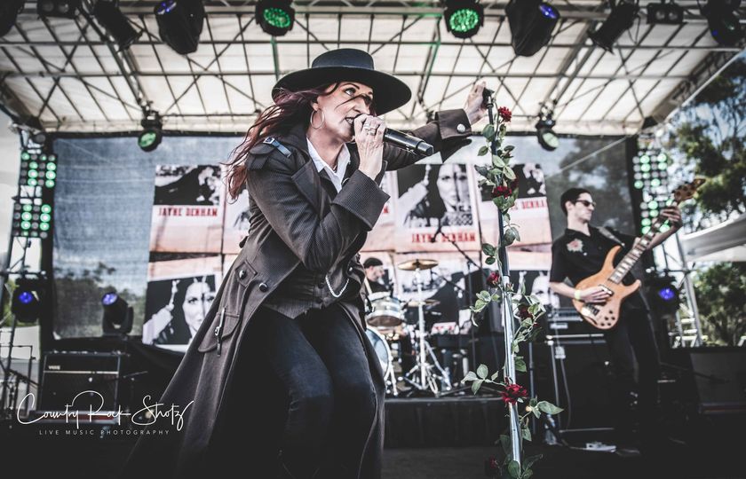 Female country music singer on stage with band.