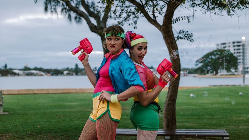 Brightly dressed female performers with bubble guns on the Mandurah Eastern Foreshore.