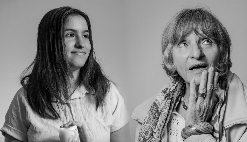 A black and white image of two women, one young woman with dark hair holding a candle, and one older woman with her hand on her face, showing off a bangle