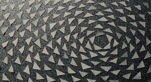 small silver triangles laid out in concentric circles on a black background