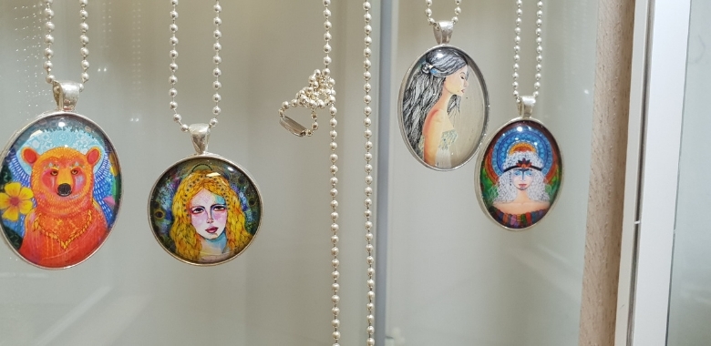 Necklace pendants hanging in a glass case