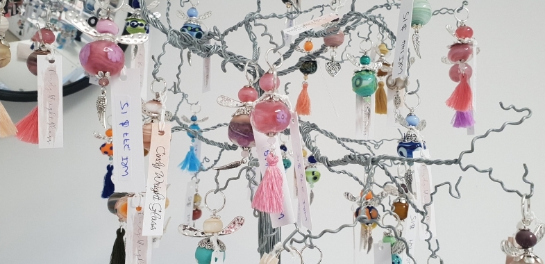 Decorated glass beads hanging from a small tree ornament