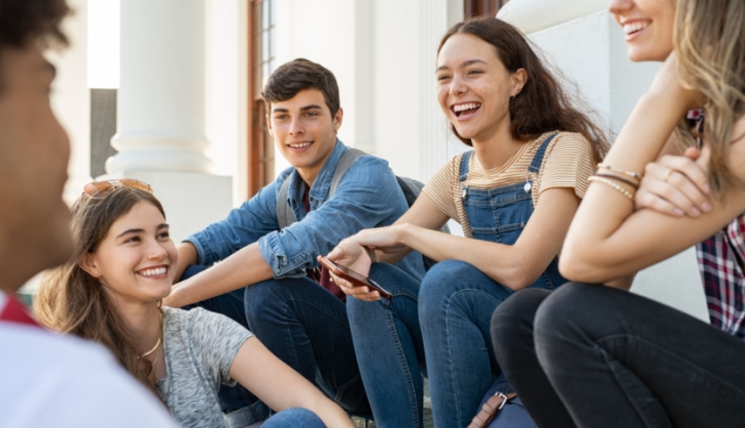 Group of five teens smiling.