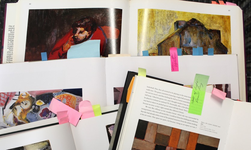 Four open books, with pages marked by sticky notes.