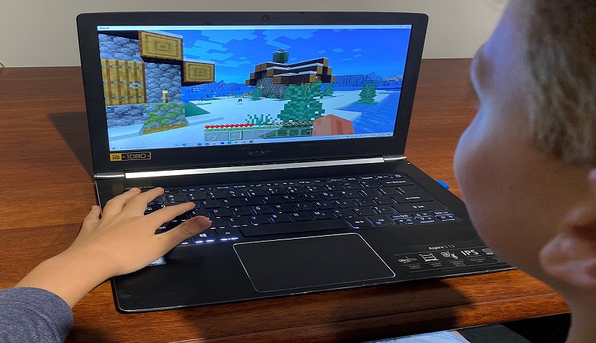 Person playing Minecraft on a Laptop