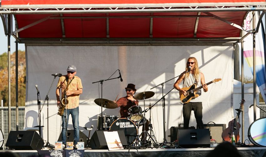 A group of musicians performing onstage at a festival
