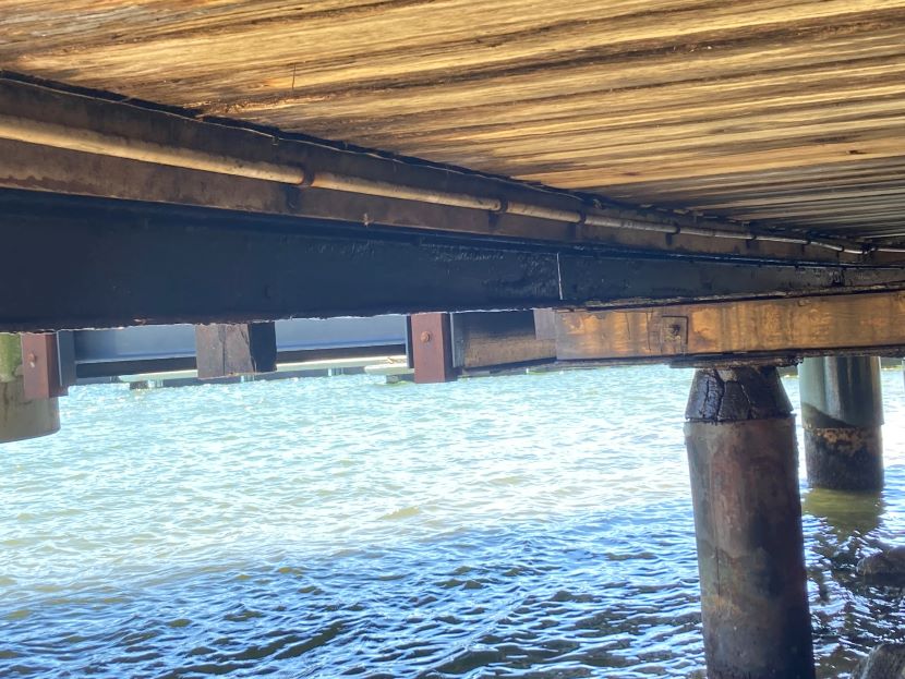 underneath the boardwalk view showing water and pillars