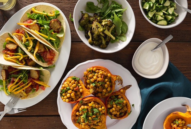 Assortment of colourful plant-based foods served on white dinner plates