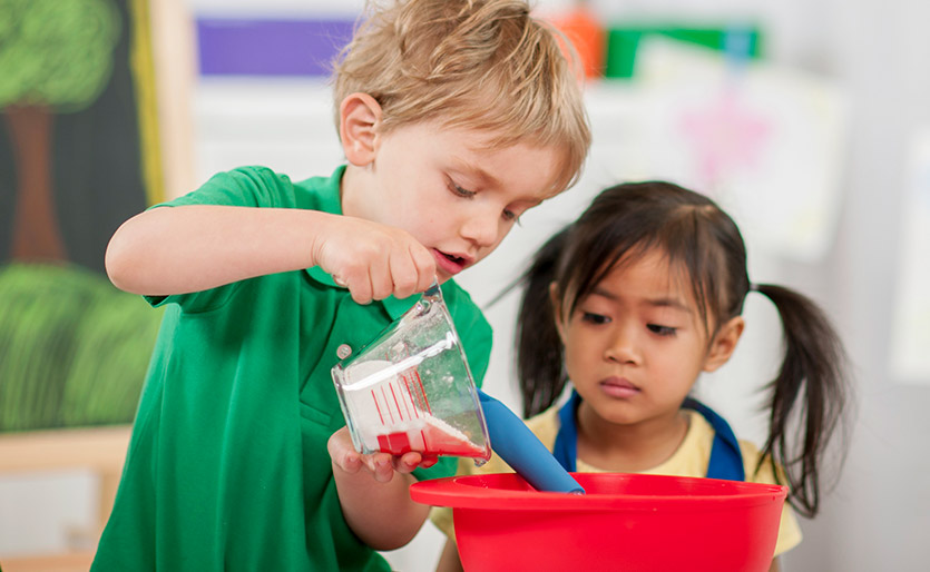 Young children mixing cooking ingredients