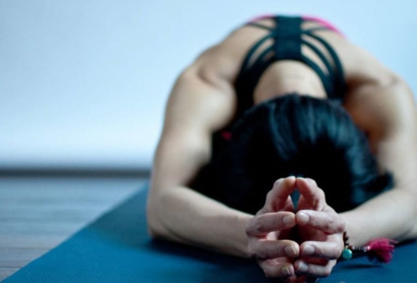 Woman doing yoga pose on a blue mat