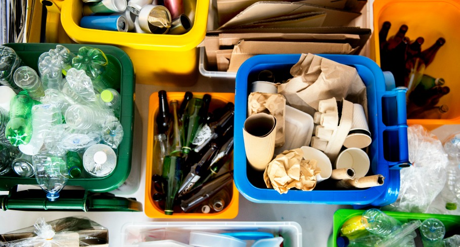 paper, glass and cardboard recycling separated into different coloured bins 