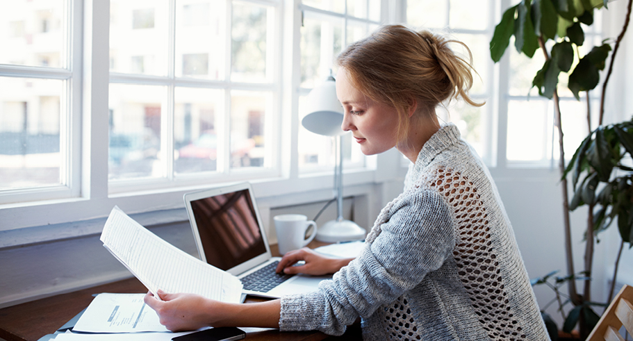 Young lady paying bills online at desk