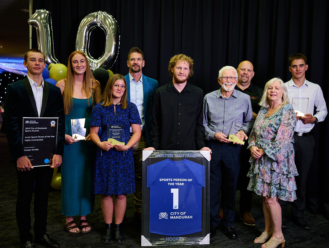 Award winners stand side by side holding their awards