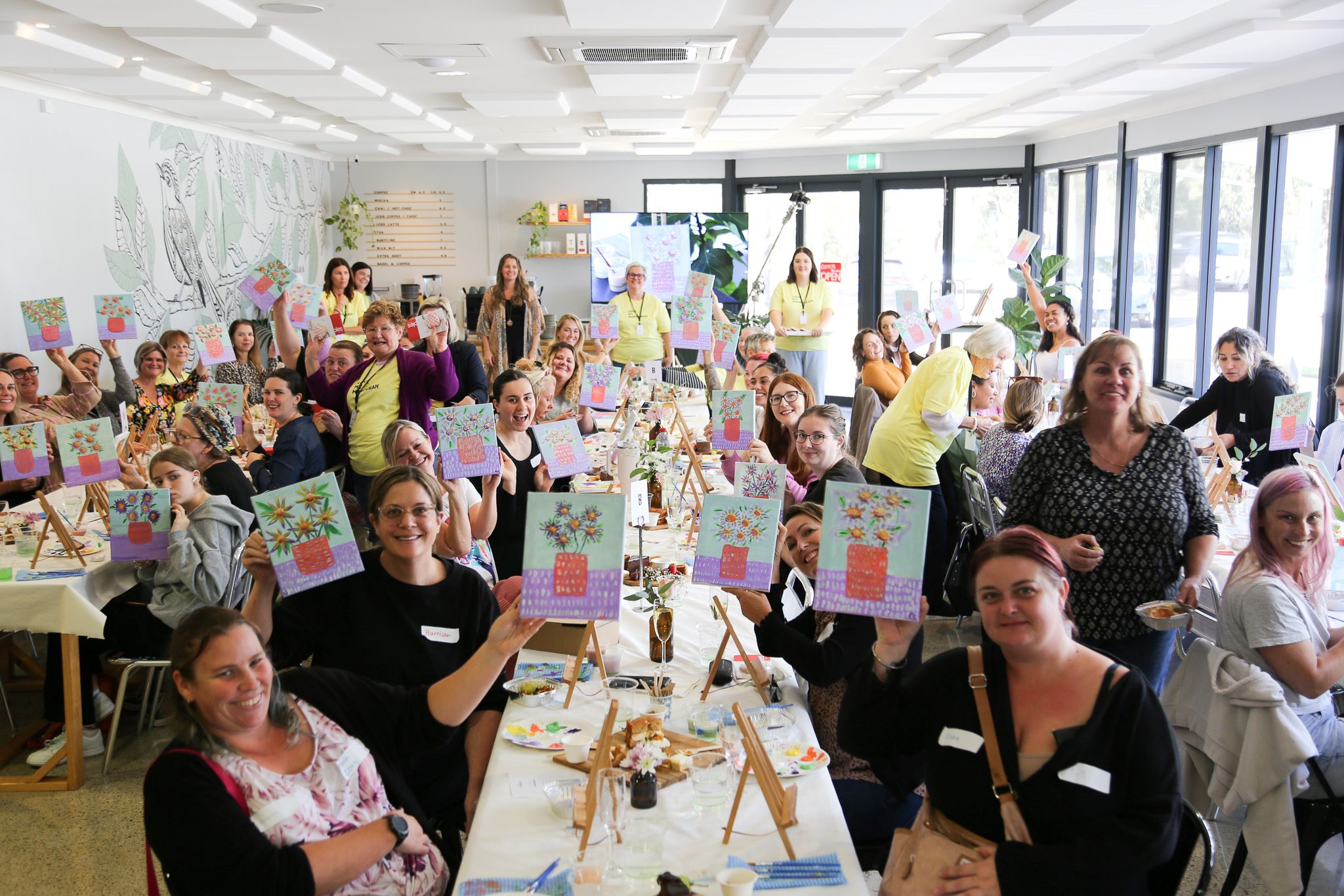 community art group with their works smiling at camera