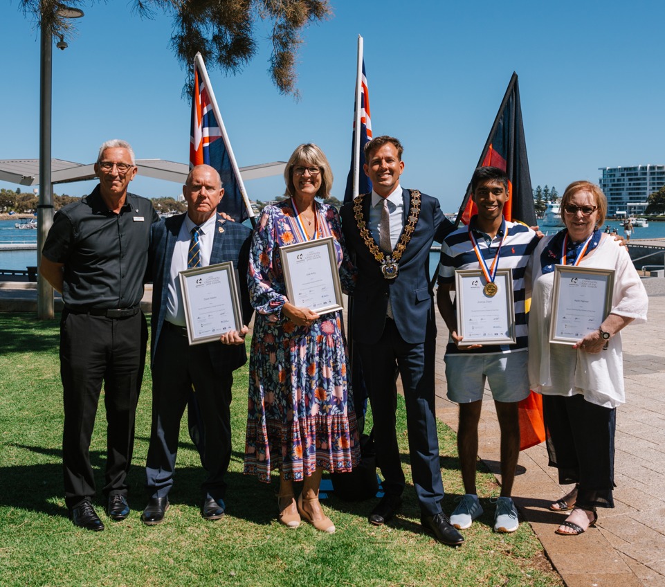 Winners of the Citizen of the Year awards stand side by side with Mayor Rhys Williams, Mandurah estuary in background