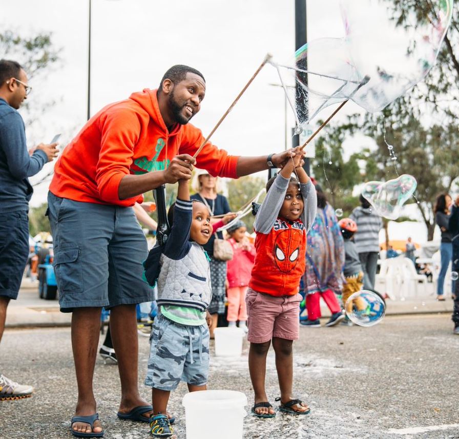Father and sons standing making bubbles