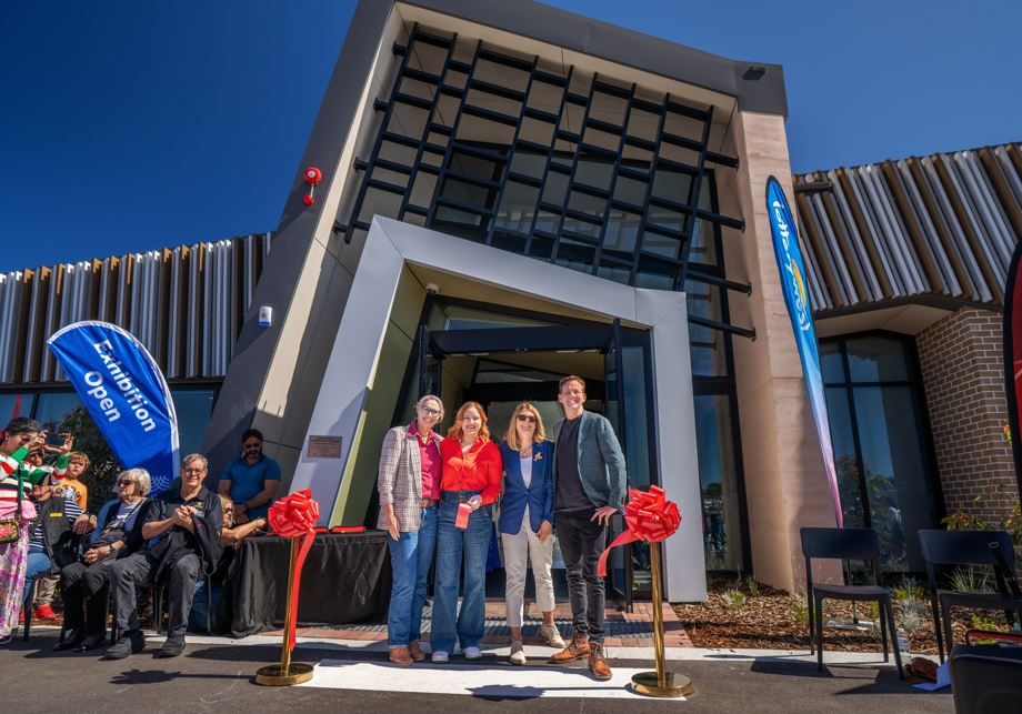 Four people pose for photo outside the new community centre