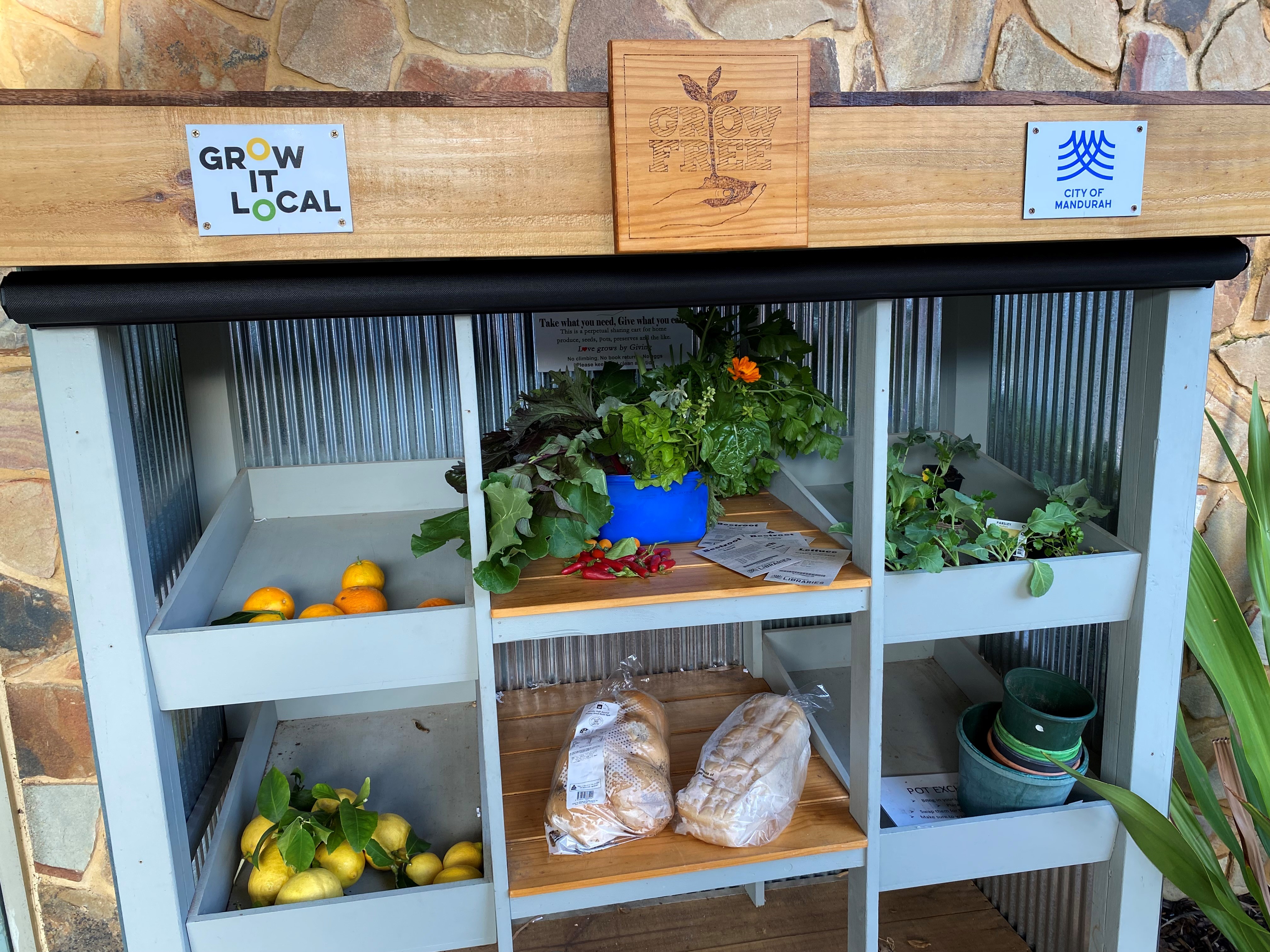 Image of the Grow It Local cart with shelves filled with fresh fruit, vegetables, and bread.