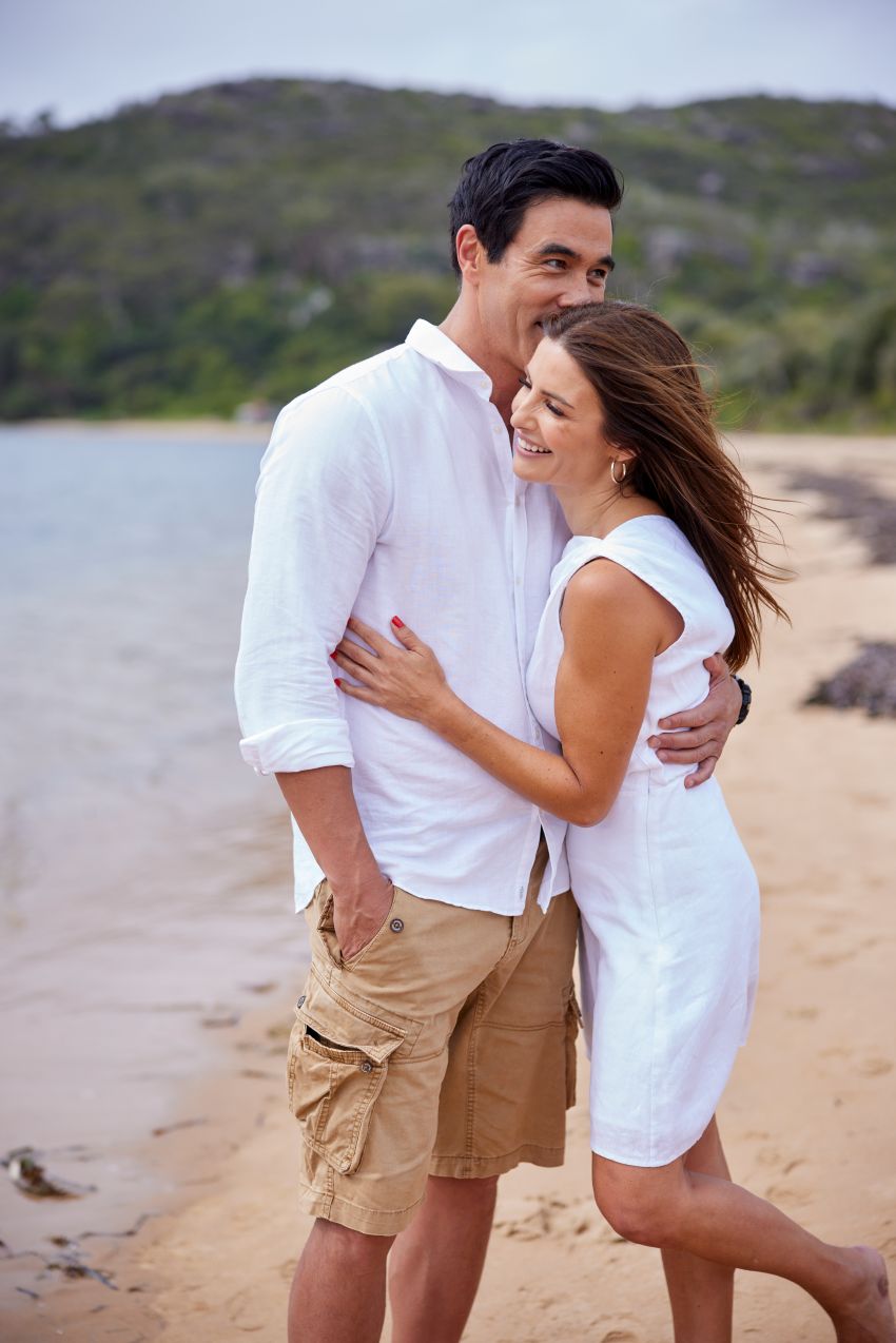 Home and Away actors hugging on beach