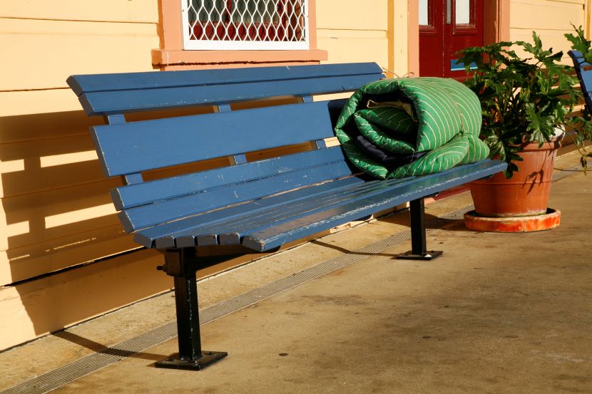 bench with rolled up mattress on it