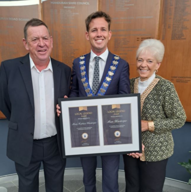 Mary and Alan Wardroper stand with award presented by Mayor Rhys Williams
