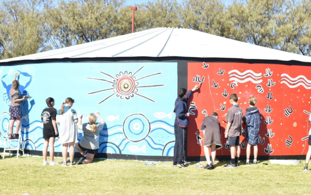 Students painting a mural on water tank