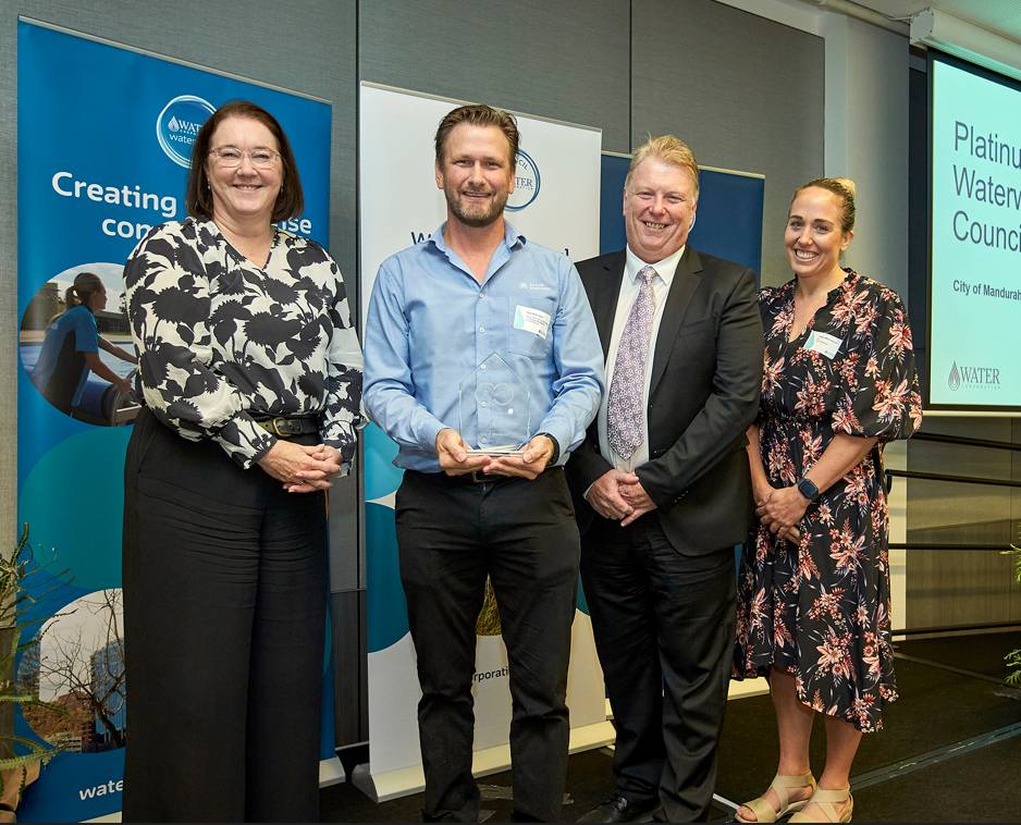 Four people stand side by side at awards ceremony