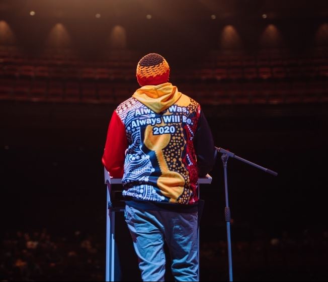 Man on stage with back to camera