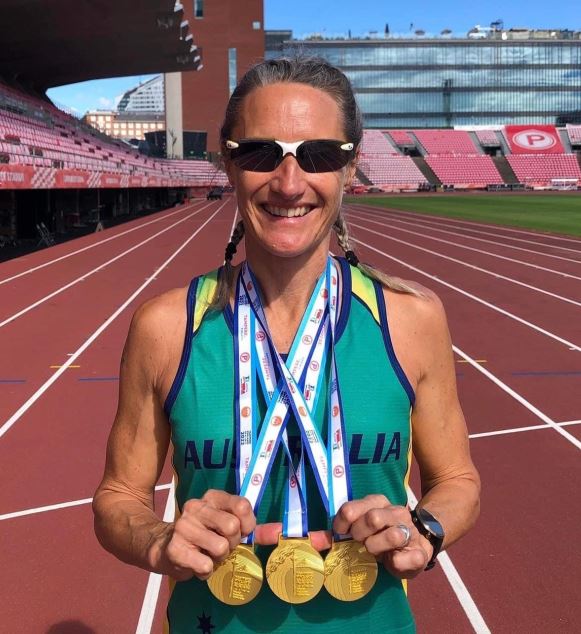 Athlete Sharon Davi stands with gold medals around her neck