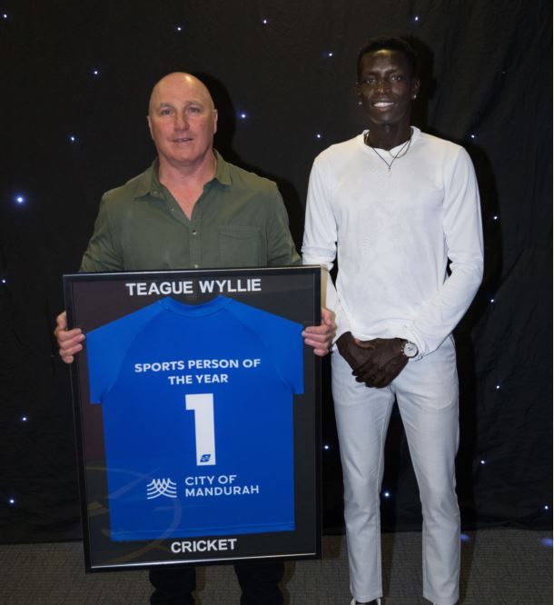 John Wyllie hold framed sports award, standing next to Peter Bol