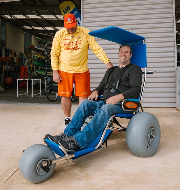 surf life saver with person using beach wheelchair