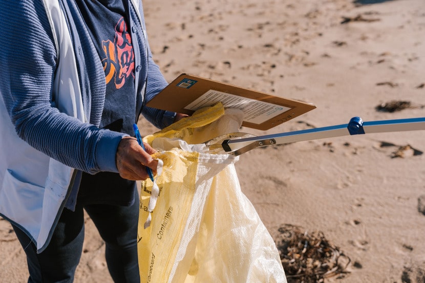 Volunteer collecting litter during a beach clean-up