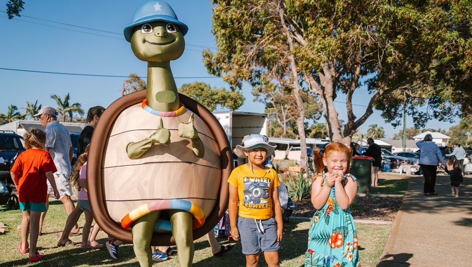 Yakkan the Turtle Mascot standing next to two children at a City of Mandurah event