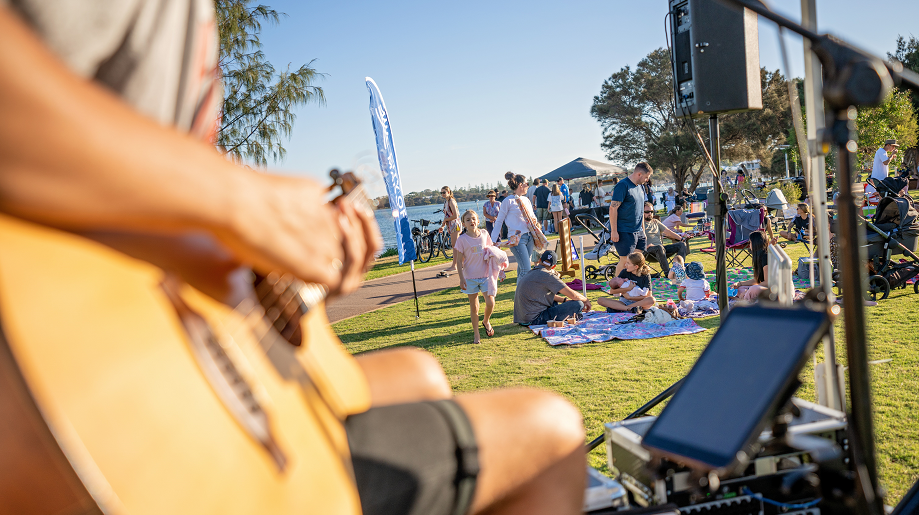 Shot of man playing acoustic guitar on a stage