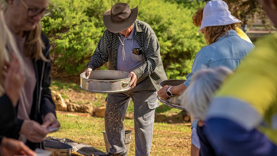 Elderly man with a hat panning for artefacts during the Archaeological Dig
