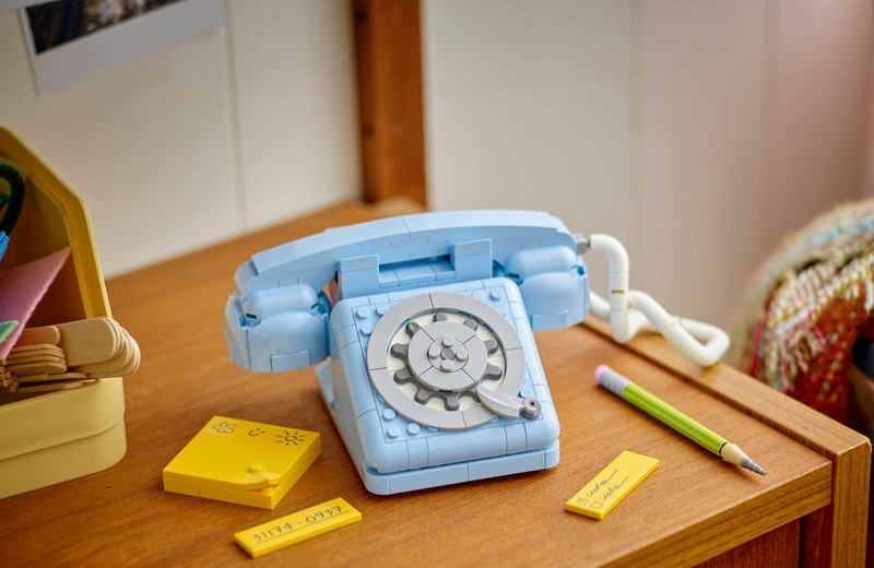 Assembled LEGO Telephone sitting on top of a wooden desk.