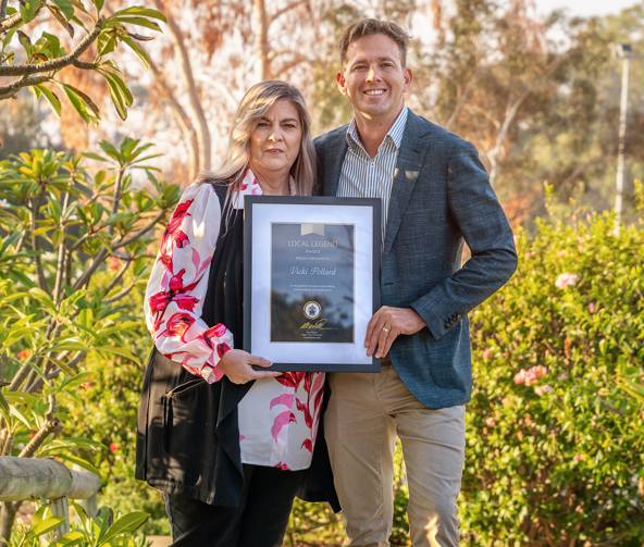 Local Legend Vicki Pollard and Mayor Rhys Williams standing side by side with greenery in background