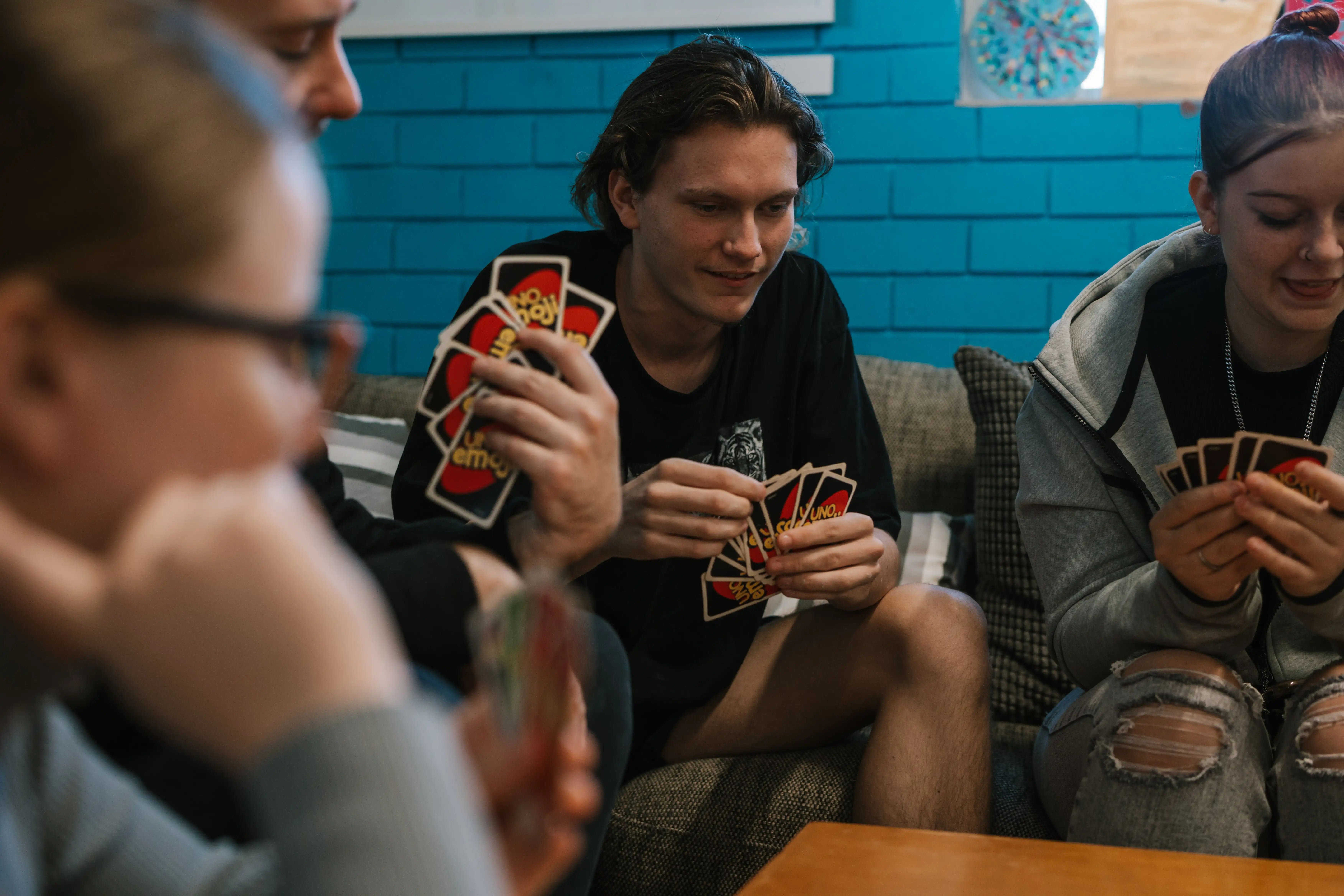 people playing cards on sofa. 