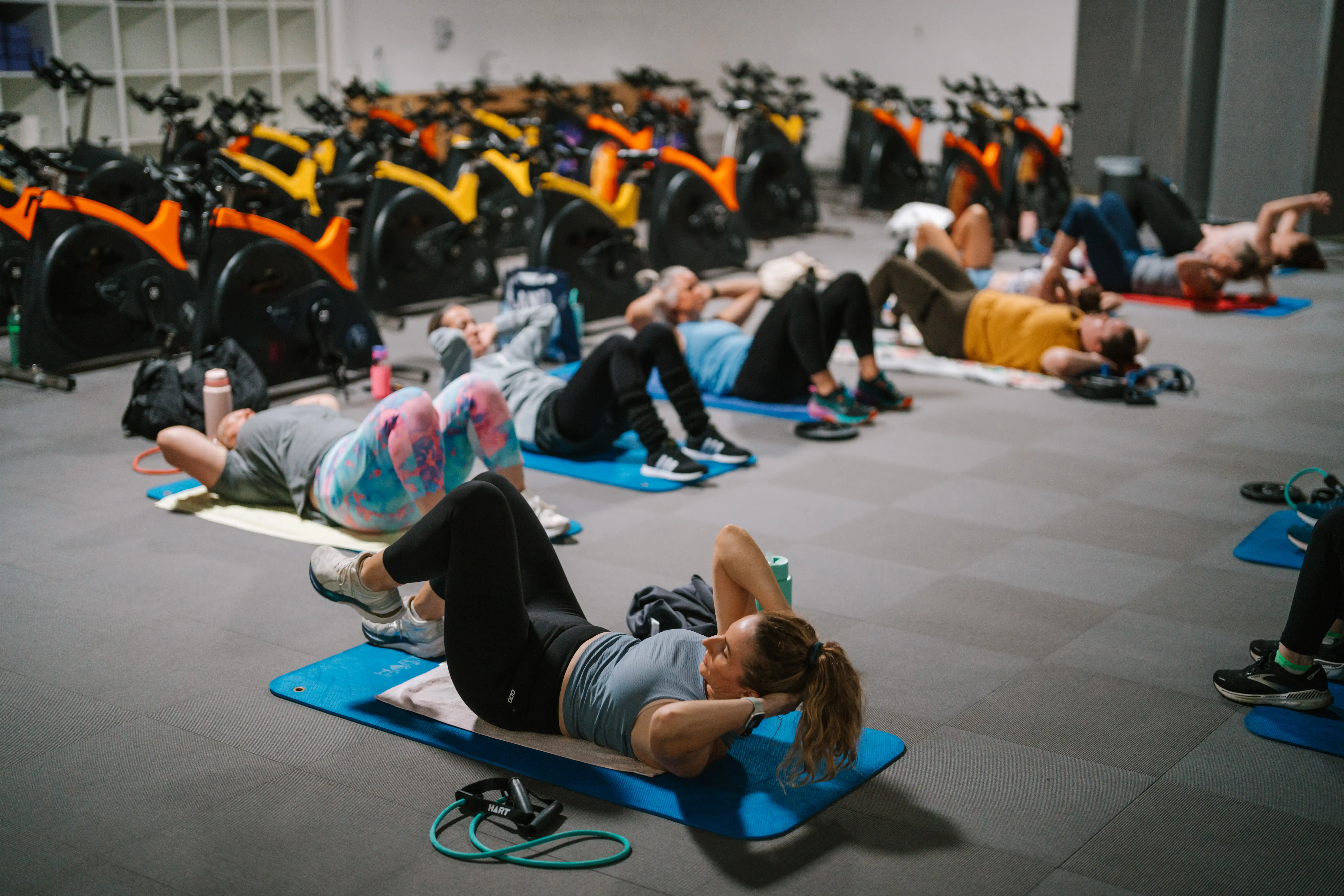 Group of people laying on the gym floor doing an ABT class