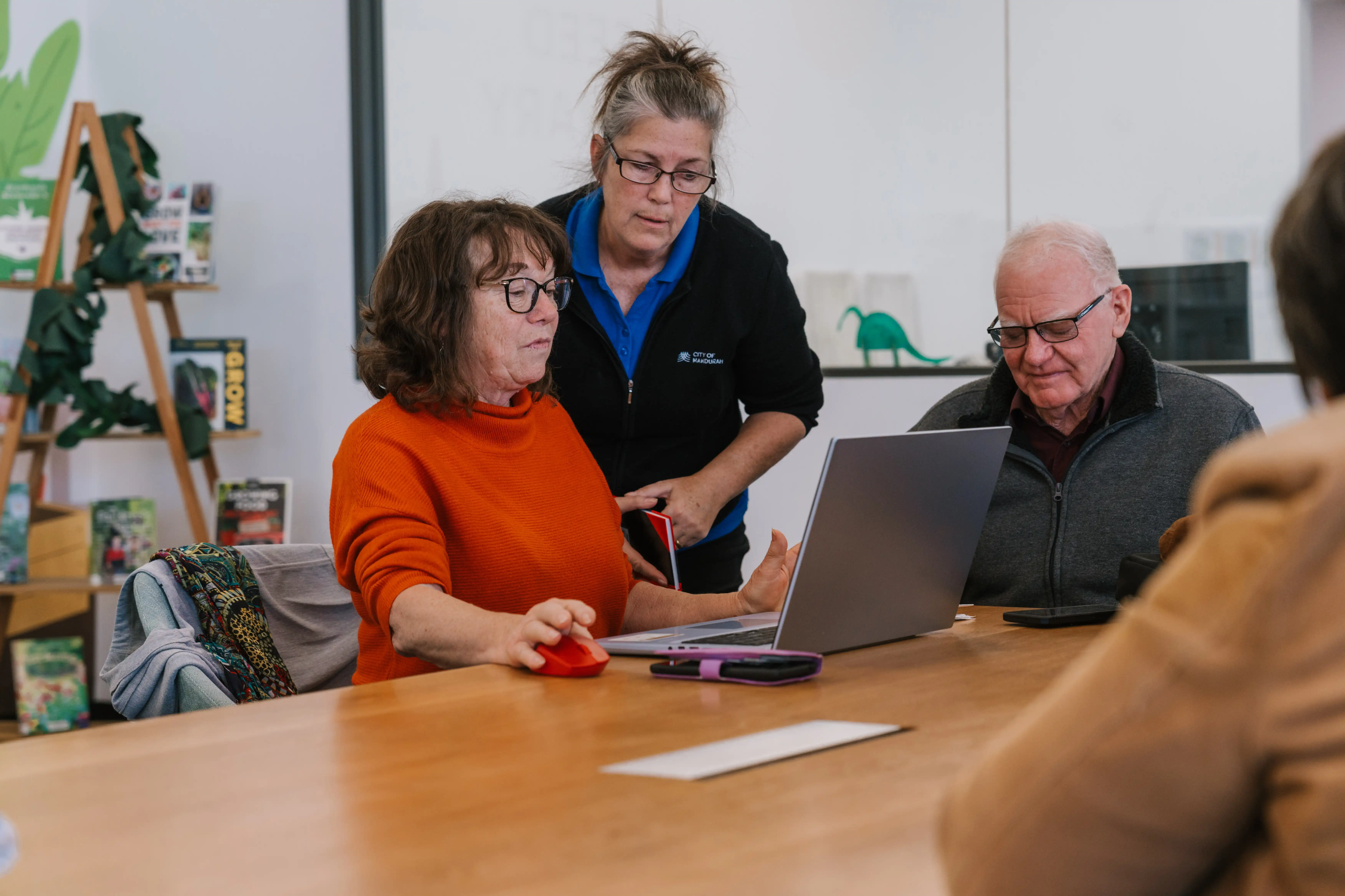 Staff member assisting person on laptop. 