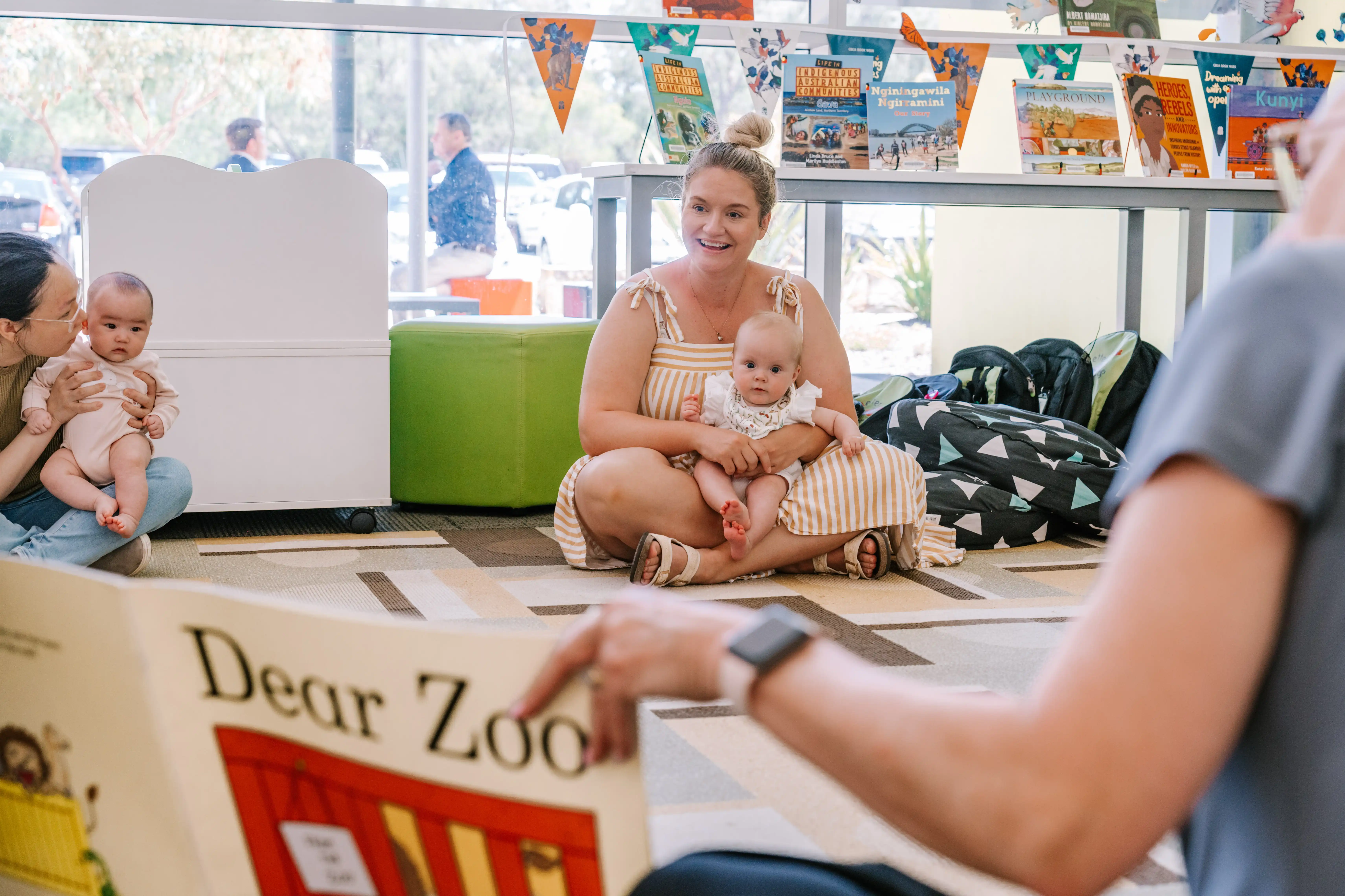 Mother and baby listening to book being read by staff.