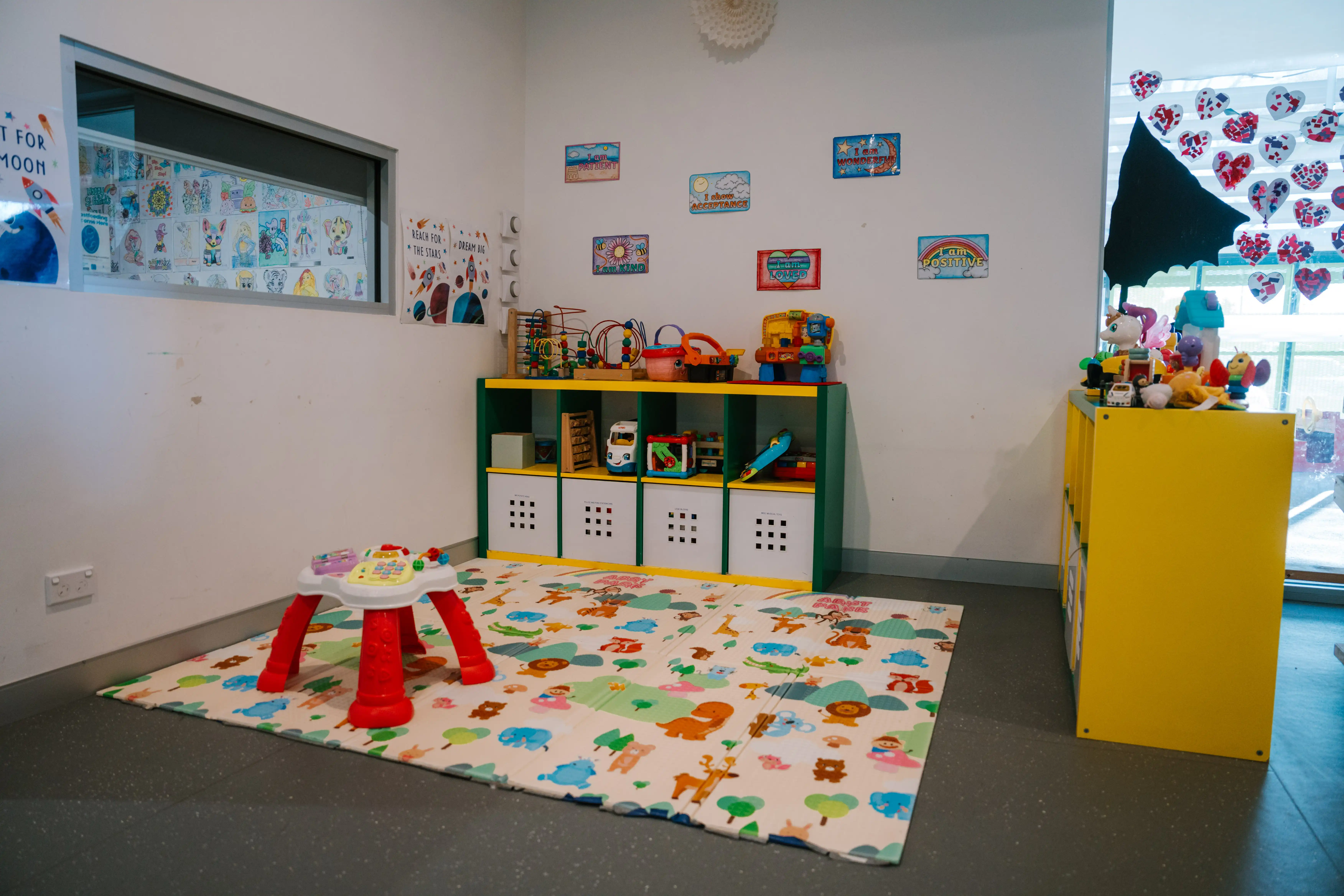 Toddler play corner with toys and soft mat at the MARC crèche.